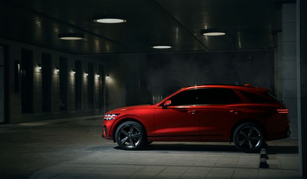 a red car alone in a parking lot at night