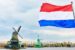 A Picture of a red, white and blue dutch flag with a windmill in the background