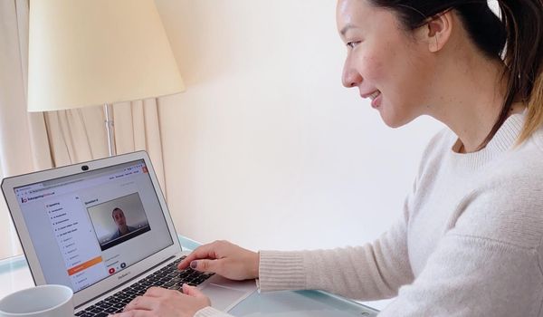 A woman sitting at a computer studying the Inburgering changes