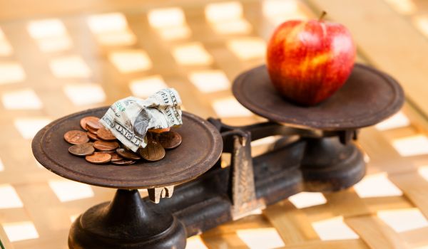 a picture of a scale with an apple and money representing inflation