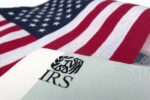 an american flag in the background with an IRS paper in the foreground representing fbar filing for expats living abroad