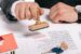 a man stamping an approved mortgage application