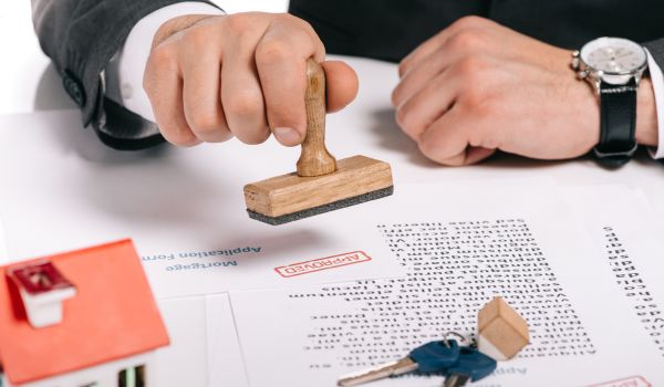 a man stamping an approved mortgage application