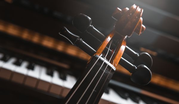 the end of the violin in front of a piano