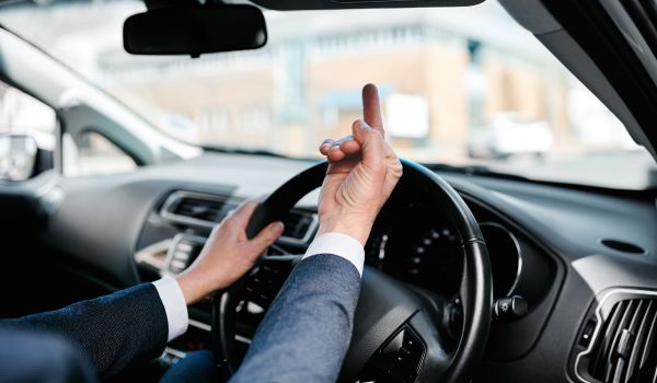 a man in a car giving the middle finger