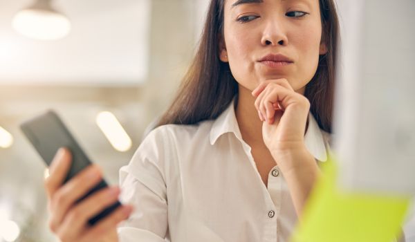 a woman staring at her phone suspiciously