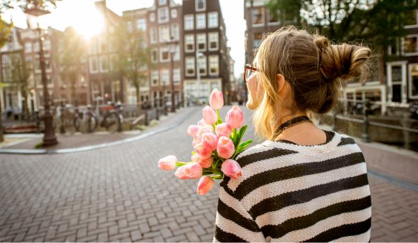 a female tourist holding tulips in amsterdam
