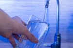 a man's hand pouring a glass of drinking water in the netherlands