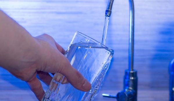 a man's hand pouring a glass of drinking water in the netherlands