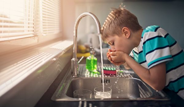 a young buy tasting the drinking water in the netherlands