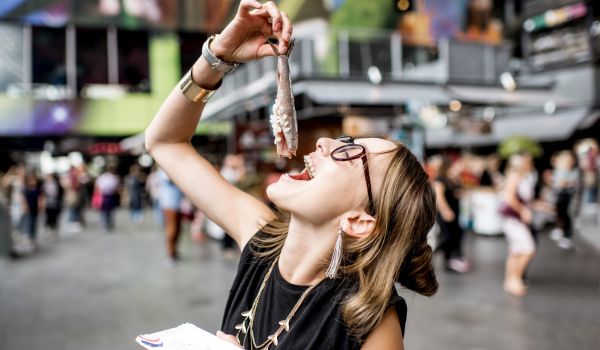 a young Dutch girl eating a raw herring snack