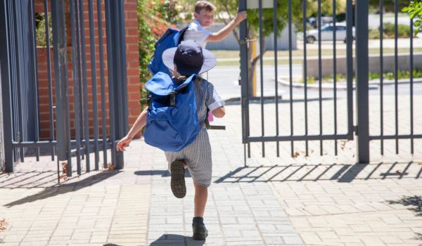 two young students running out of school