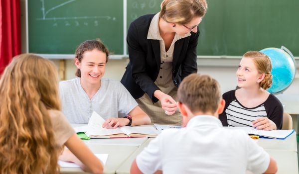 a teacher teaches students geography in secondary school