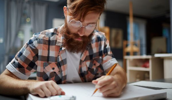 a bearded man making a rough draft