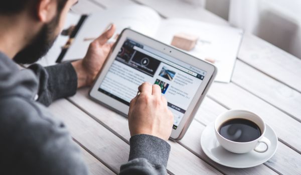 a man reading the news in the netherlands on his tablet in the morning