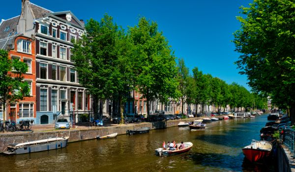 Amsterdam canaal with tourist boat and old houses