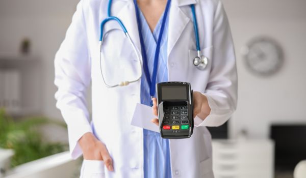 Doctor with Payment Terminal in Clinic