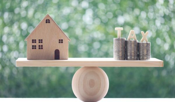 a scale representing a house on one side and transfer tax in the netherlands on the other