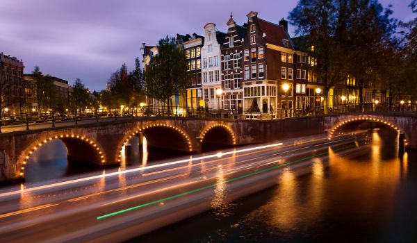 Amsterdam canal boat light trails at night