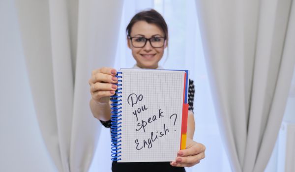 a woman holding up a sign that says do you speak english