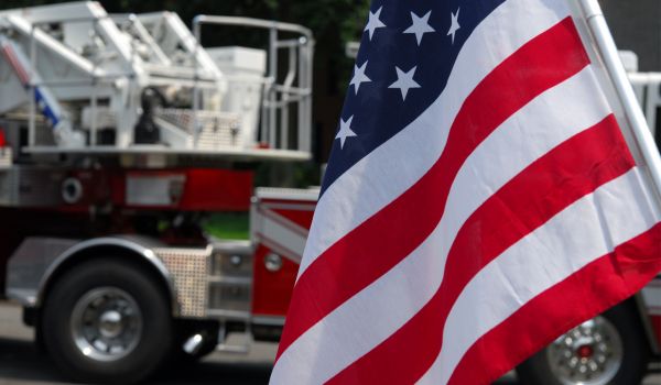an american flag in front of a fire truck
