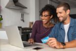 a happy young dutch couple making household payments online