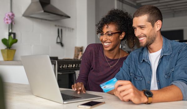 a happy young dutch couple making household payments online