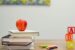 an apple on a stack of school books