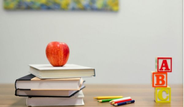 an apple on a stack of school books