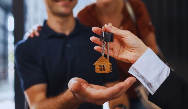 a couple buying a home as proud new homeowners