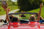 happy friends driving a cabriolet car