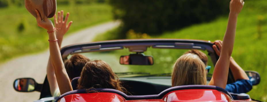 happy friends driving a cabriolet car