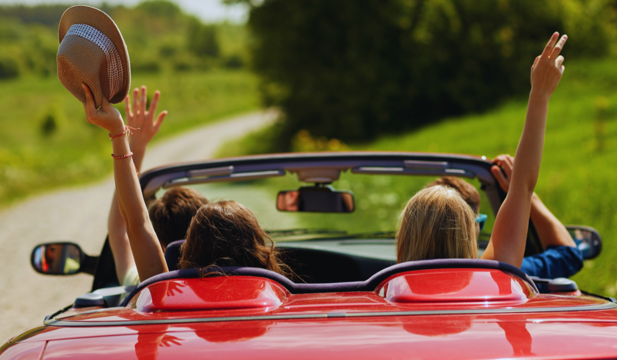 happy friends driving a cabriolet car