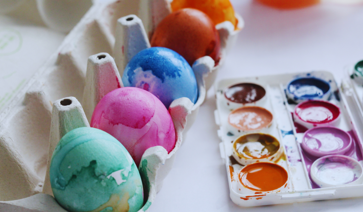 a row of freshly painted easter eggs in a carton
