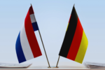 Dutch and German flags standing on a tabletop
