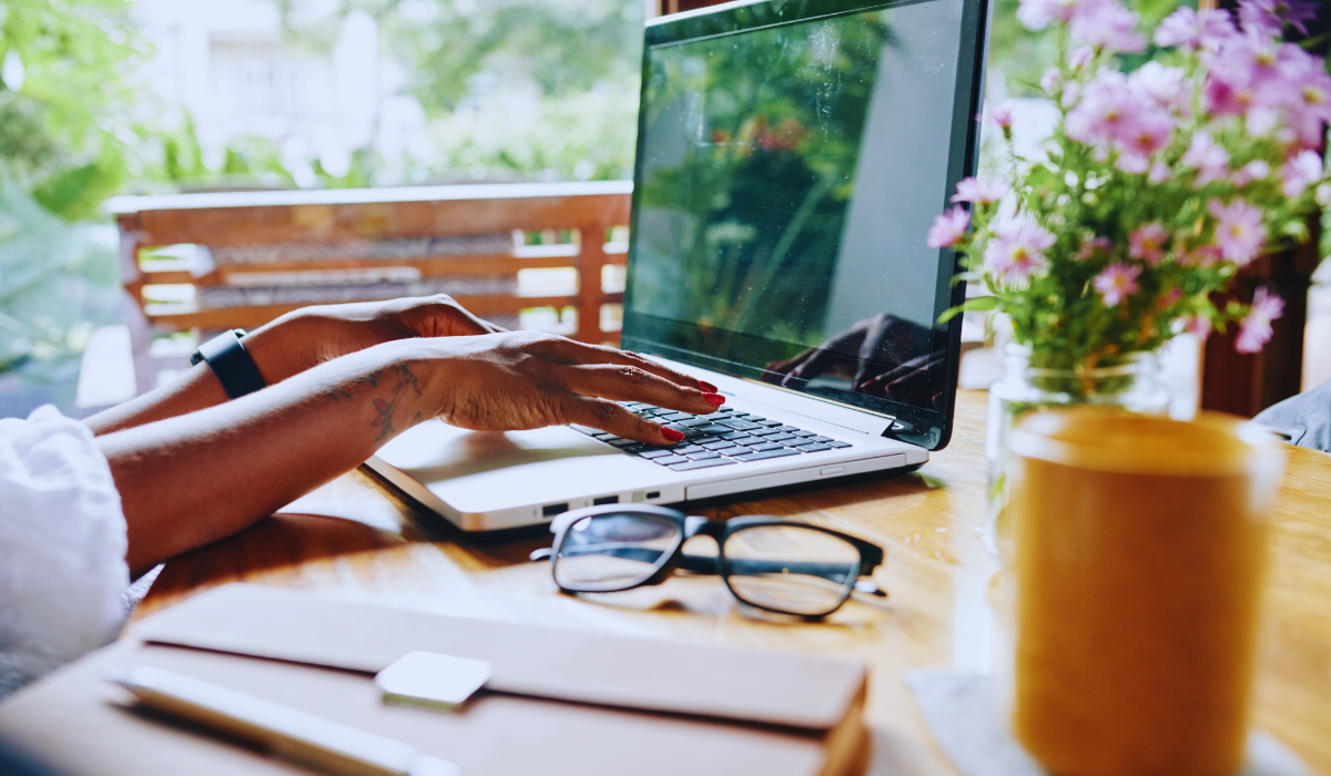 female hands typing on a laptop at home
