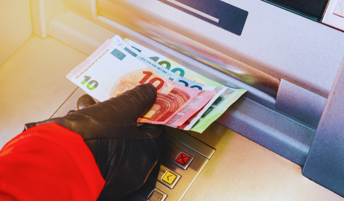 A woman taking money out of a Dutch ATM