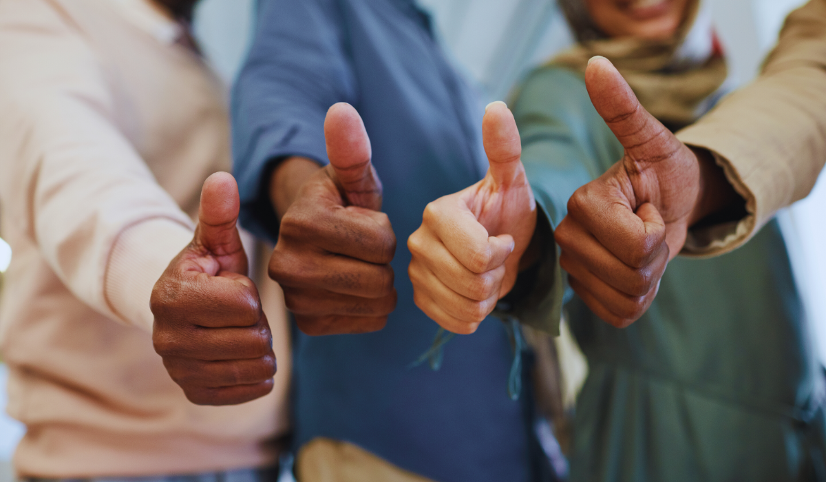 A diverse group giving thumps up