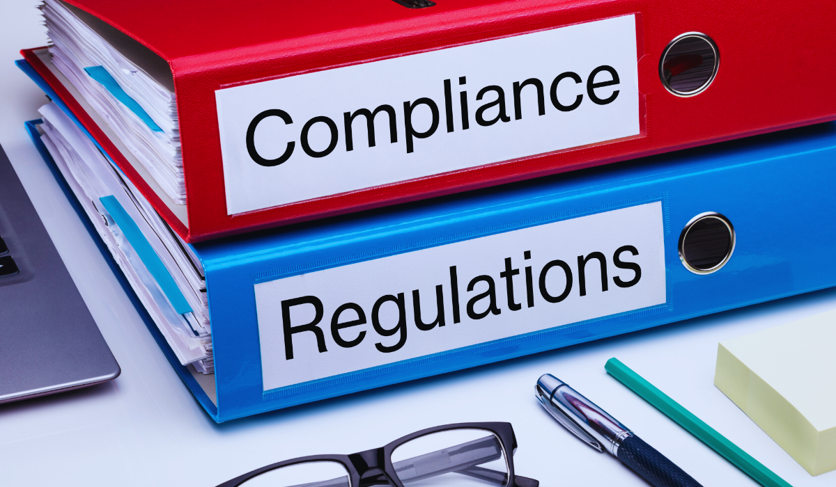 A compliance folder stacked on top of a regulation folder