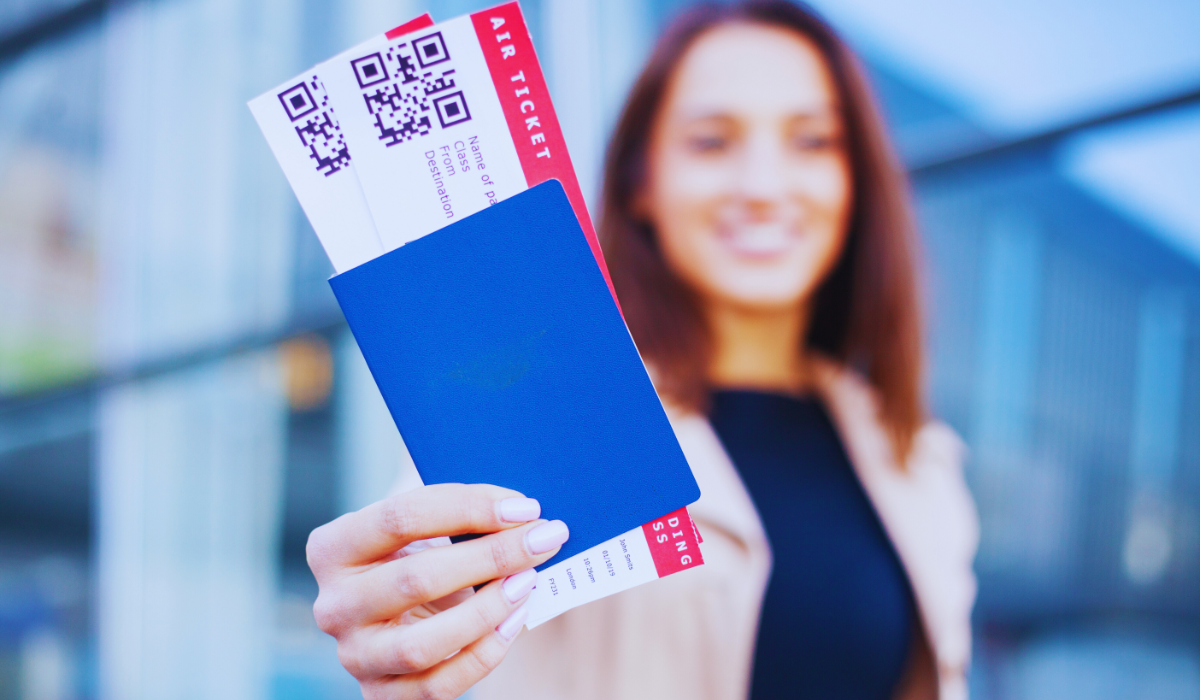 A woman holding a pair of air tickets