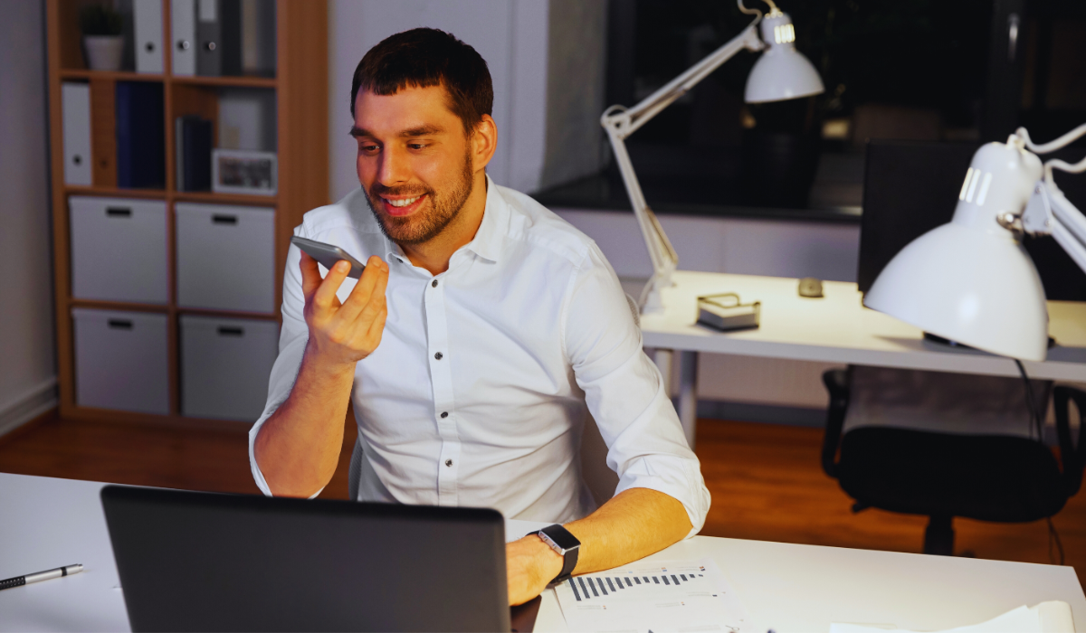 A businessman recording a voice message on his phone