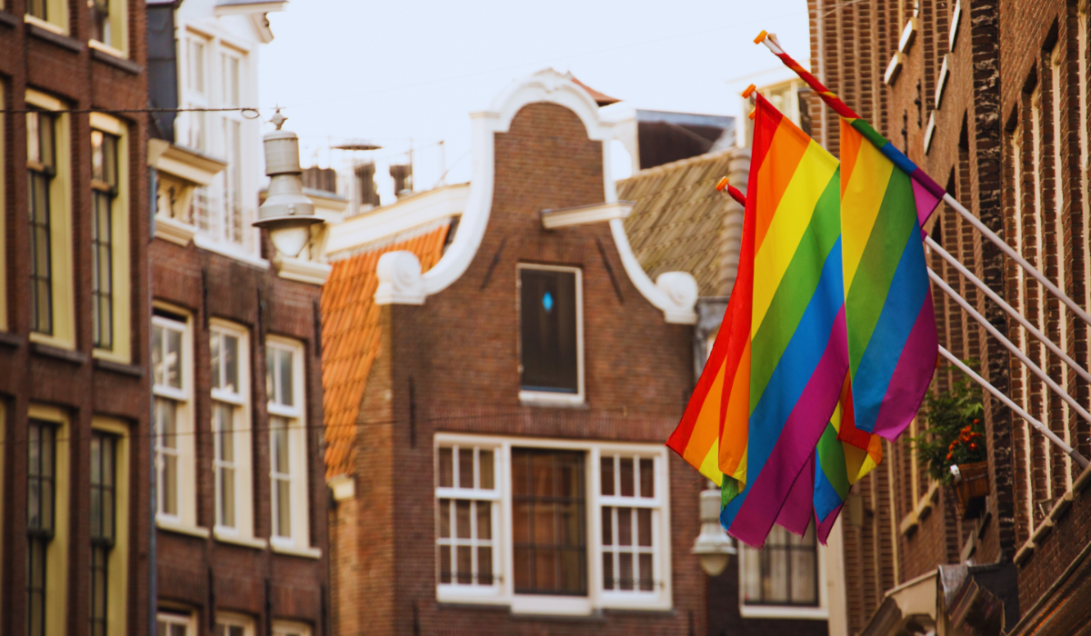 Two pride flags hanging outside a building in Amsterdam