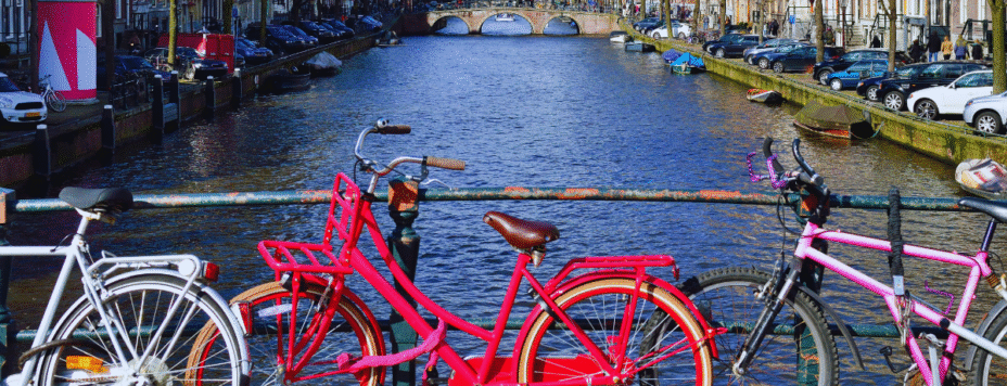 Three bikes against a canal on a sunny day in the netherlands