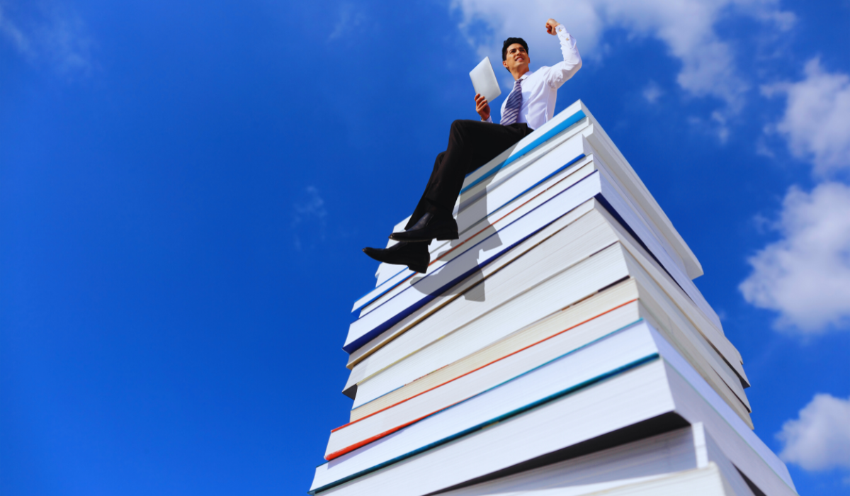 a man sitting atop a stack of books
