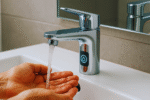 hands under a modern faucet with flowing water