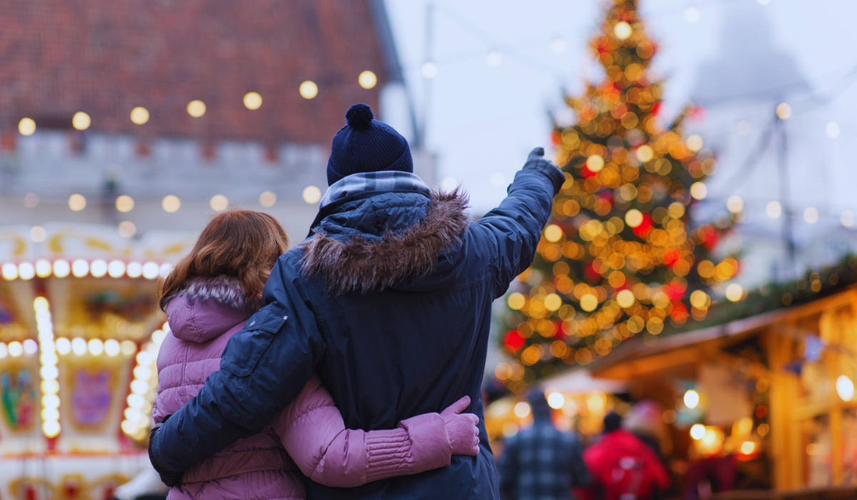 A couple pointing at a christmas tree at a market in the Netherlands