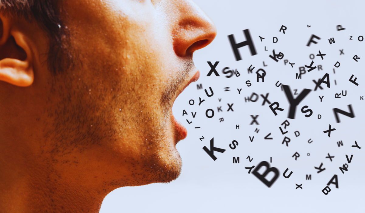 Close up of a man's mouth with letters spewing out