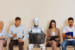 A Robot and Dutch workers waiting in line for a job interview