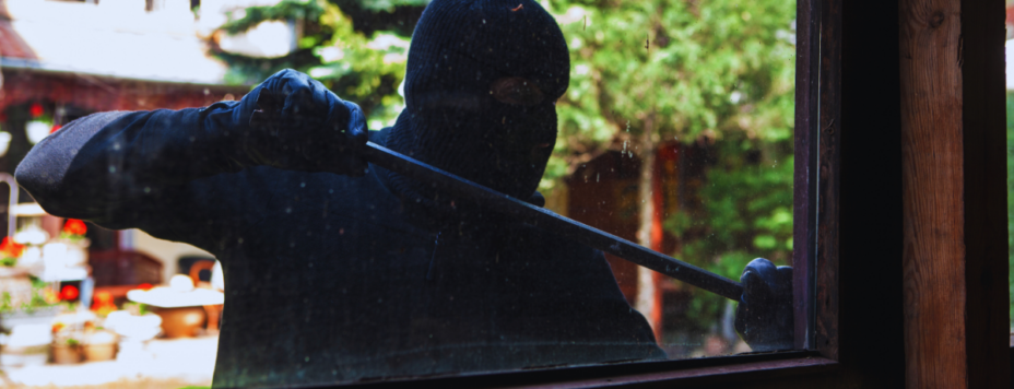 A burgler breaking into a Dutch house with a crowbar