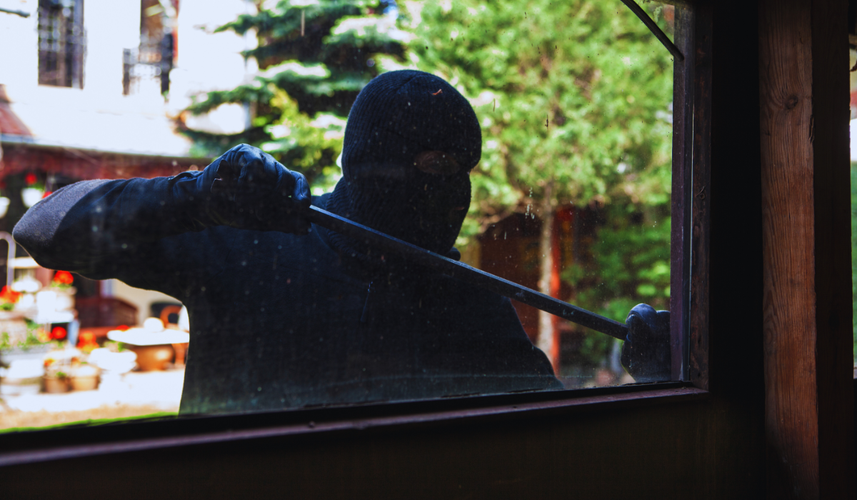 A burgler breaking into a Dutch house with a crowbar